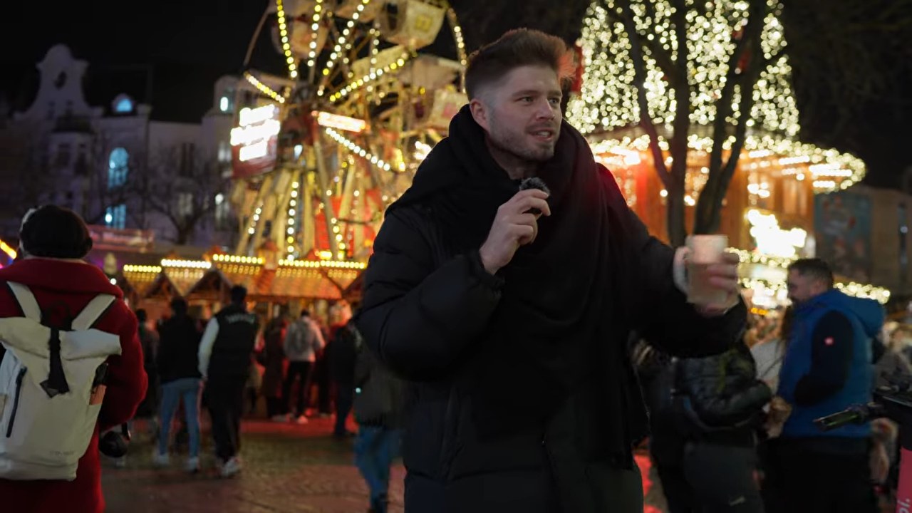 Frauen ansprechen im Winter: 7 Tipps für mehr Dates 1 Marko auf einem Weihnachtsmarkt bei Nacht, im Hintergrund Riesenrad und Lichter